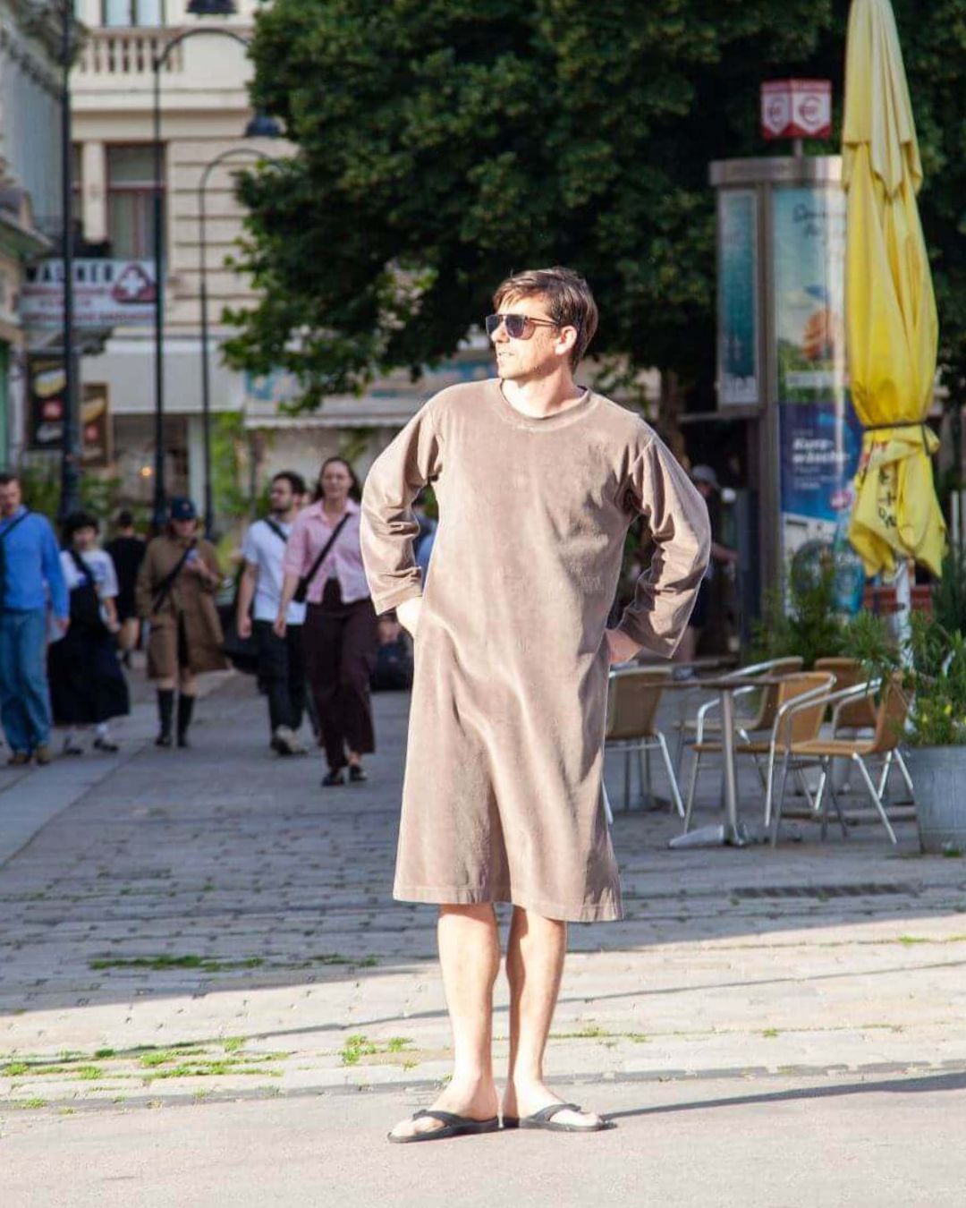 Man wearing a Sonus Aeris one-piece in taupe on a Vienna street