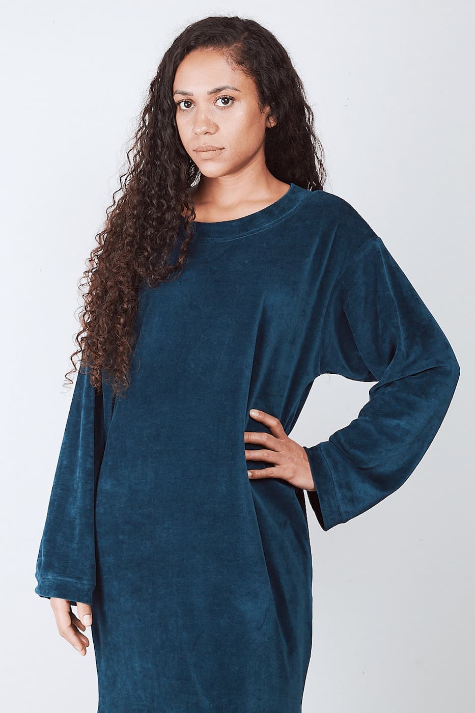 Woman in deep petrol Sonus Aeris one-piece against light background