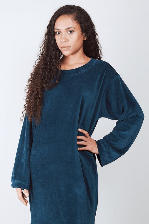 Woman in deep petrol Sonus Aeris one-piece against light background