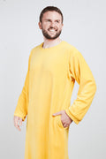 Man in gold ochre Sonus Aeris one-piece with pockets against light background