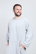 Man in light gray Sonus Aeris one-piece with pockets against light background